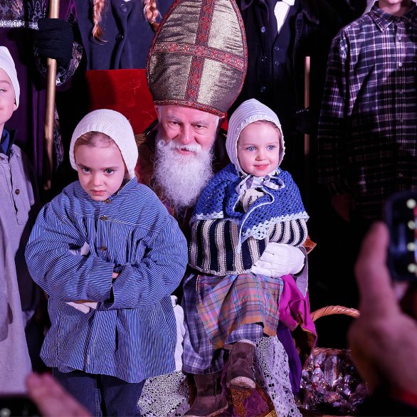 Saint Nicolas prend la pause avec les enfants tandis qu'il leur offre des friandises