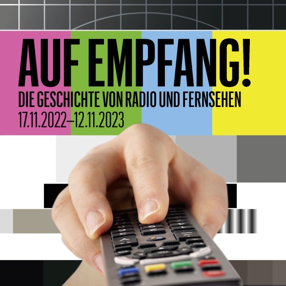 Eine Hand hält eine Fernbedienung, darüber ist der Ausstellungstitel zu sehen.