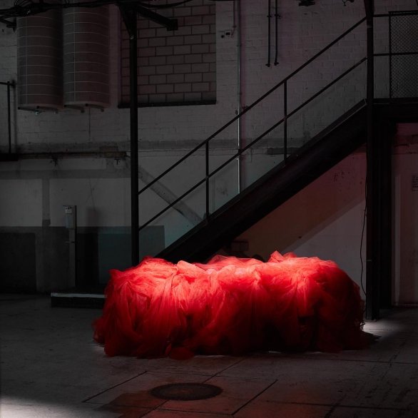 Ein rotes Objekt in einer dunklen Umgebung, Treppen im Hintergrund.