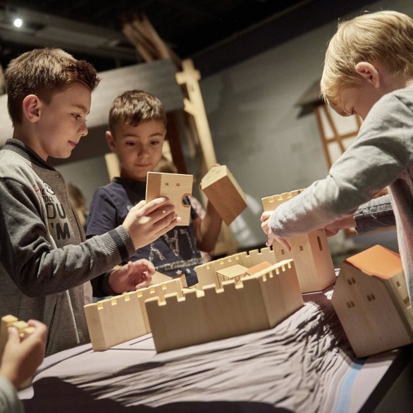 Kinder bauen ein Schloss aus Holzbausteinen. Landesmuseum Württemberg, Stuttgart; Foto: Martin Sigmund