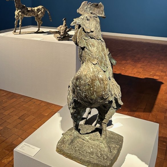 Ausstellungsansicht mit Werken von Sepp und Monika Baumhauer. Im Vordergrund ist ein Hahn aus Bronze von Sepp Baumhauer zu sehen, dahinter weitere Bronzetiere sowie Gemälde eines Leguans und eines Mandrills seiner Tochter Monika Baumhauer.