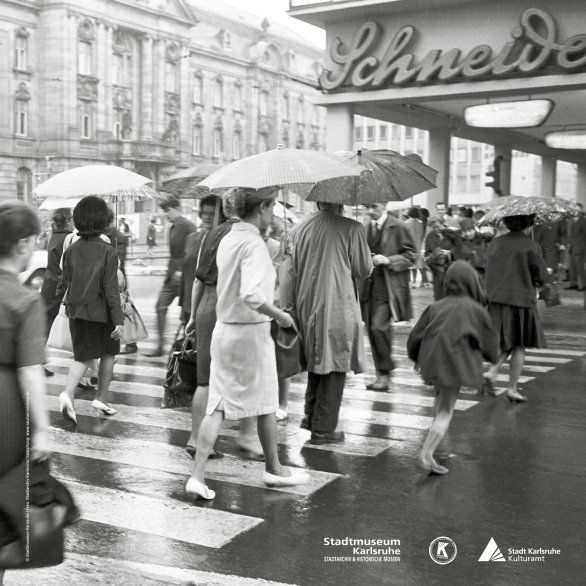 Plakat mit schwarz-weiß Fotografie von Menschen, die über einen Zebrastreifen gehen.