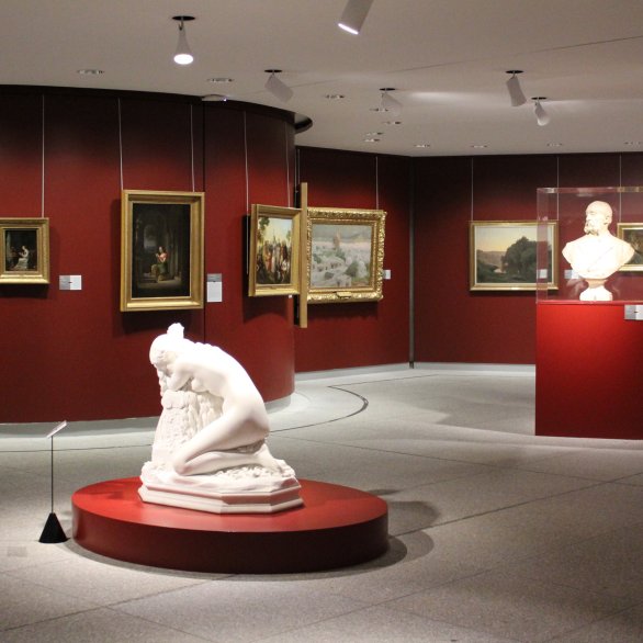 Parcours Beaux-Arts avec des tableaux au mur et des sculptures au coeur de la salle : une femme agenouillée et deux bustes d'homme