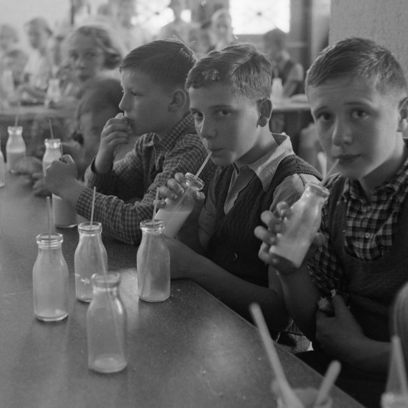 Schulkinder trinken Milch mit Strohhalmen aus Glasflaschen, 1938. Foto: Lothar Jeck, Staatsarchiv Basel-Stadt, BSL 1060c 3/10/47