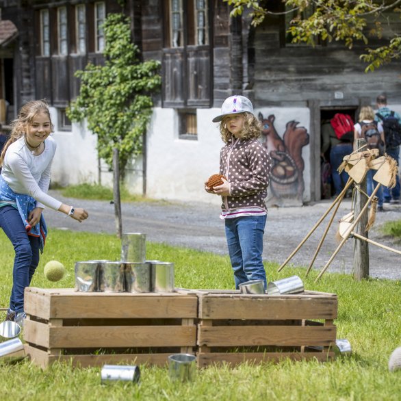 Children throwing cans at the Ballenberg Open-Air Museum.