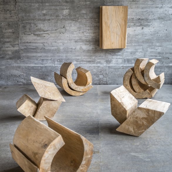 Holzskulpturen Rudolf Wachters vor grauer Betonwand