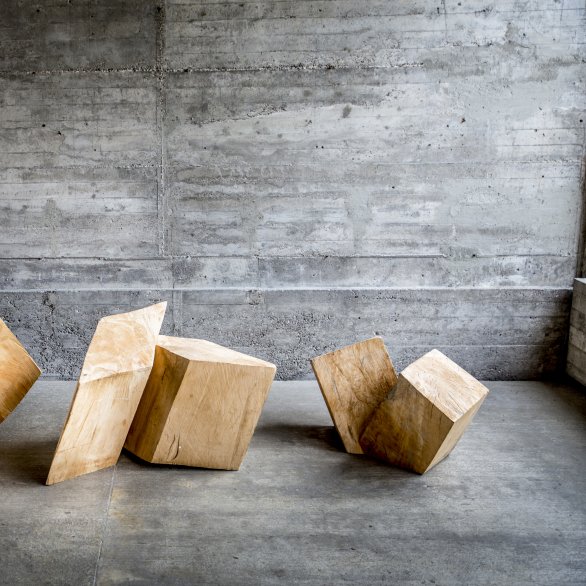 Holzskulpturen Rudolf Wachters vor grauer Betonwand