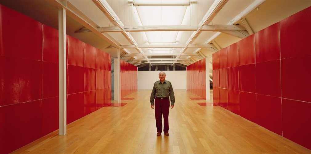 Künstler in einem großen raum umgeben von roten Wänden