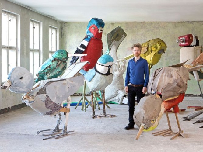 Der Künstler Matthias Garff steht in seinem Atelier zwischen seinen überlebensgroßen Vogelskulpturen