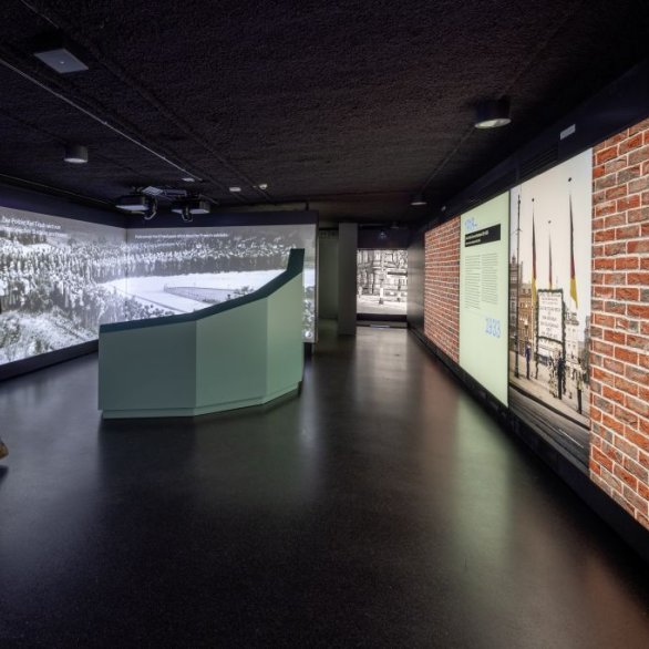 Blick in den Raum, der sich mit der Weimarer Republik befasst. . Menschen vor großen Monitoren, die Wahlplakate zeitgenössischer Parteien zeigen.