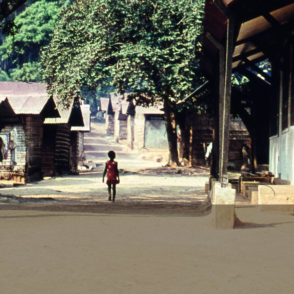 Enfant marchant au cœur du village hôpital, et plus précisément du village lumière dédié aux malades de la lèpre, de Lambaréné, au Gabon