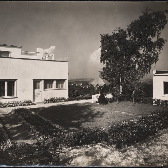 Schwarz-weiß-Fotografie eines modernen Hauses mit Flachdach und Garten