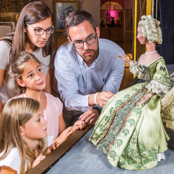 Familie betrachtet Puppen