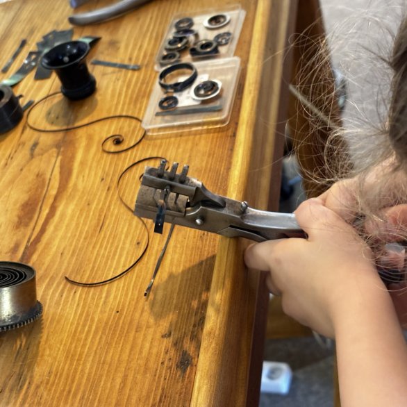 Un petit garçon de 4 ans s'applique à essayer la pince ancestrale aux yeux de ressorts.